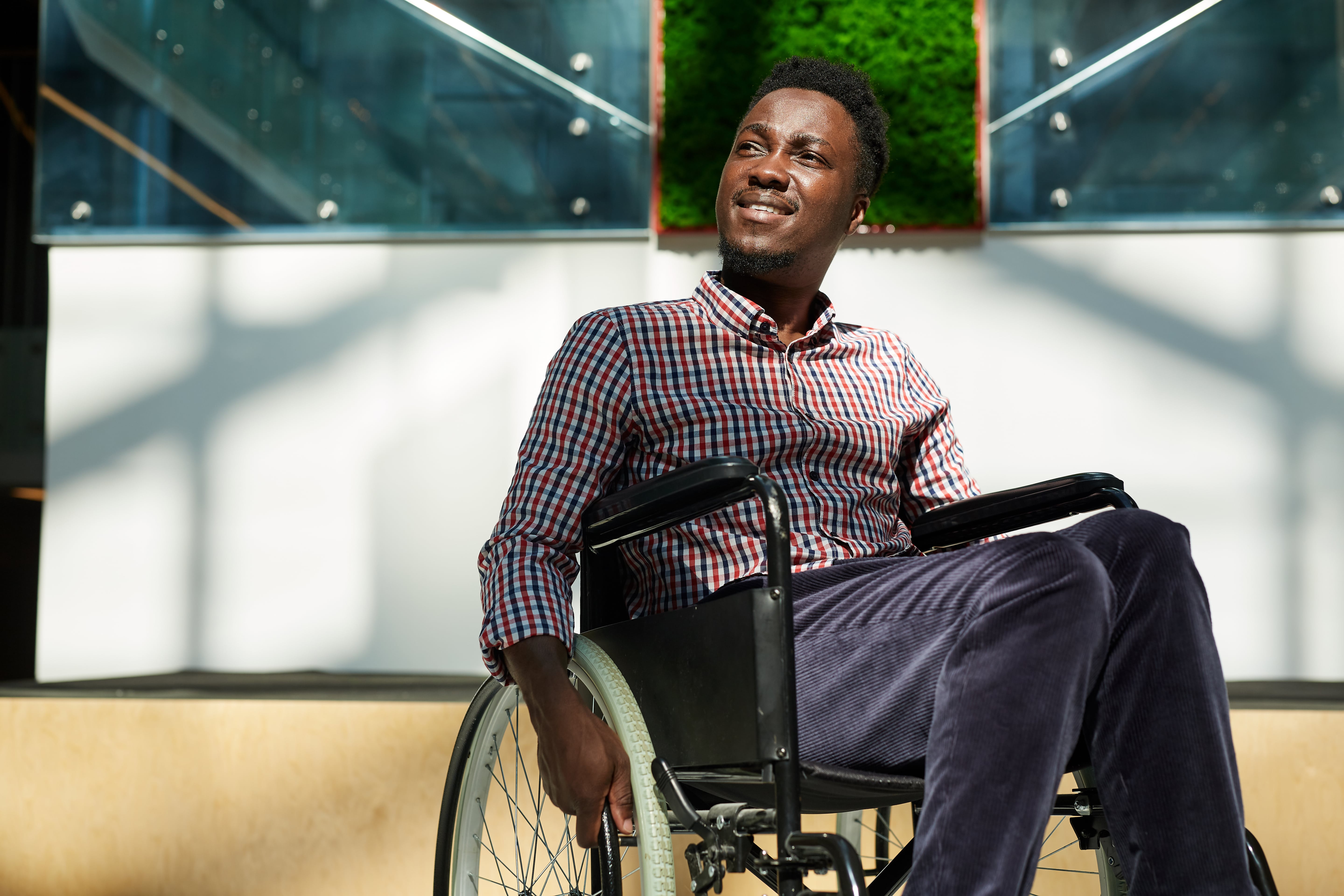 Man using a self propelled wheelchair in the sun